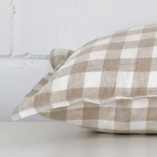 A sideways perspective of this gingham designer cushion. The positioning shows the border of the rectangle shape.