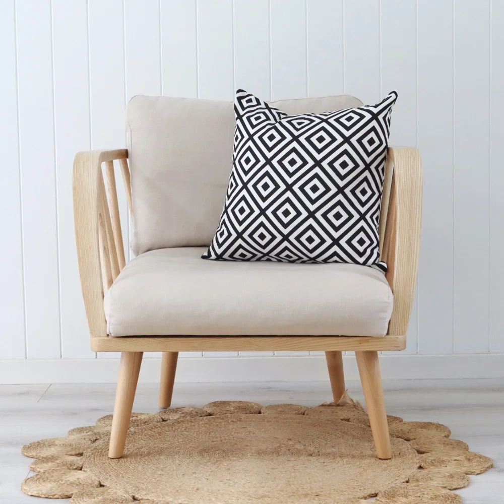 A geometric cushion with eye catching design is styled on a chair.