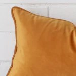 Very close photo of gold mustard cushion. The shot shows the velvet material and rectangle dimensions with more clarity.