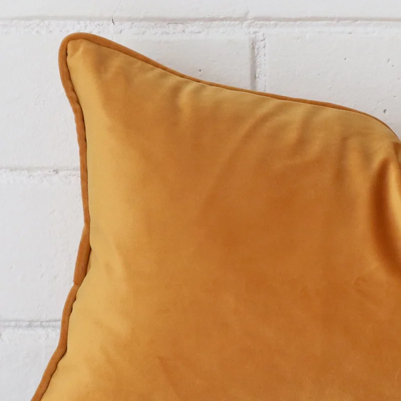 Very close photo of gold mustard cushion. The shot shows the velvet material and rectangle dimensions with more clarity.
