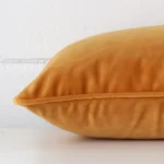 Lateral viewpoint of this velvet rectangle cushion. The TYPE design and gold mustard colour are shown from the side showing the front and rear panels.