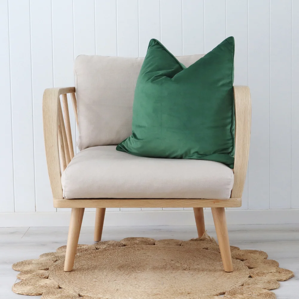A green cushion sits vertically on a light coloured chair inside.