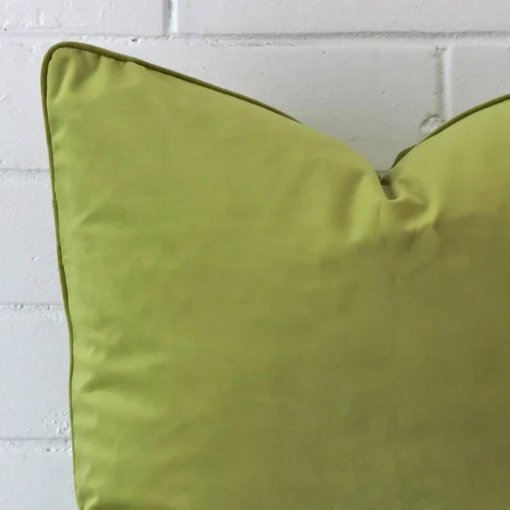 The corner of this velvet square cushion cover is shown close up. The design and green velvet colour are shown in greater detail.