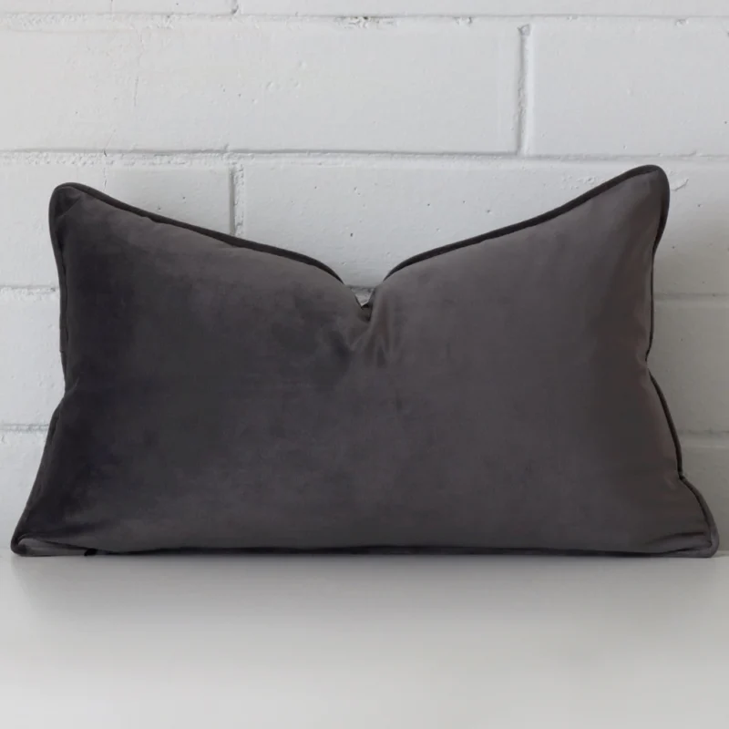 grey-velvet-rectangle-cushion-cover-30cm-x-50cm-sc424-30 Grey cushion cover sits against a white wall. It is constructed from a superior looking velvet material and has rectangle dimensions.
