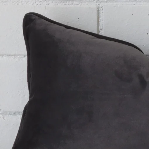 A macro image of the top left corner of this velvet cushion. It is possible to see the finer detail of the rectangle shape and grey colour.