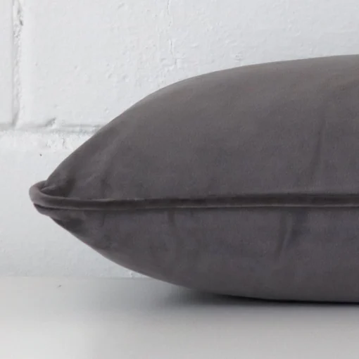 Velvet grey cushion laying on its side. It has a rectangle shape.