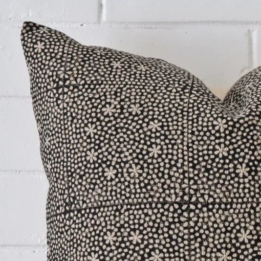 Close range image of cushion. The square size and designer material can be seen in detail.