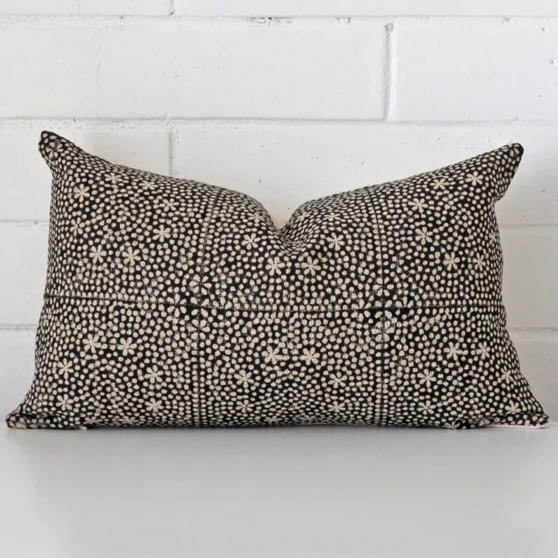 hali-designer-cushion-cover-rectangle-art115-30 White wall with a cushion laying against it. It has a distinctive designer fabric and has a rectangle shape.