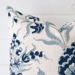 Corner section image showing features of square cushion that has a patterned motif on its linen fabric.