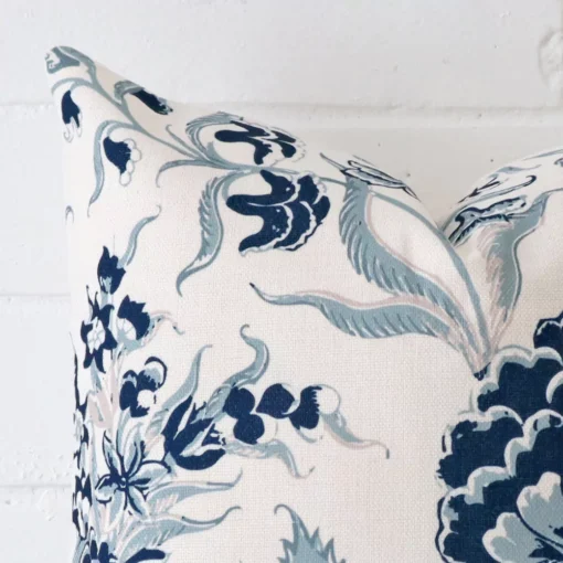 Corner section image showing features of square cushion that has a patterned motif on its linen fabric.