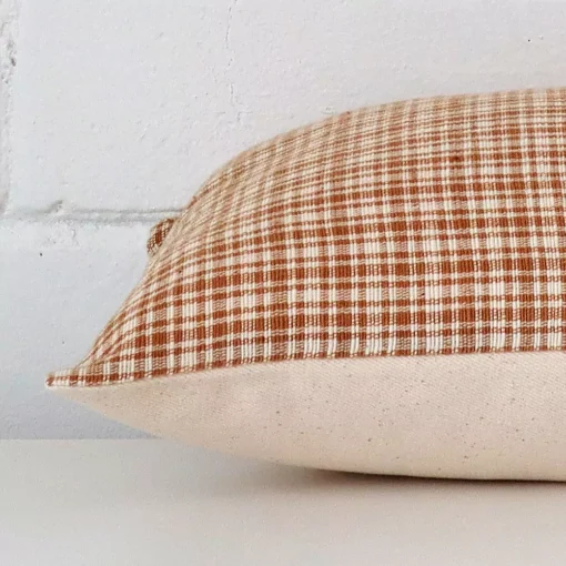 Square cushion laid flat. This view shows the gingham style and designer fabric from side on.