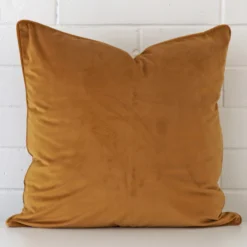 An eye-catching velvet square cushion cover featuring a hue that is honey mustard.