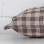 Rectangle cushion laid flat. This view shows the gingham style and designer fabric from side on.