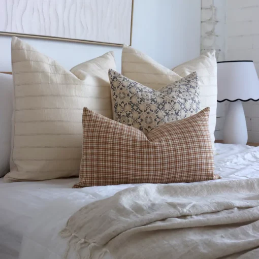 An image showing four designer bed cushions in a white-themed bedroom.