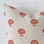 Precision shot of this square rust cushion cover. It is possible to see the floral style and linen fabric in greater depth.