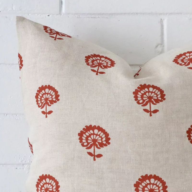 Precision shot of this square rust cushion cover. It is possible to see the floral style and linen fabric in greater depth.