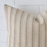 Zoomed in visual of designer square cushion cover. The intricacies of its striped design are visible.