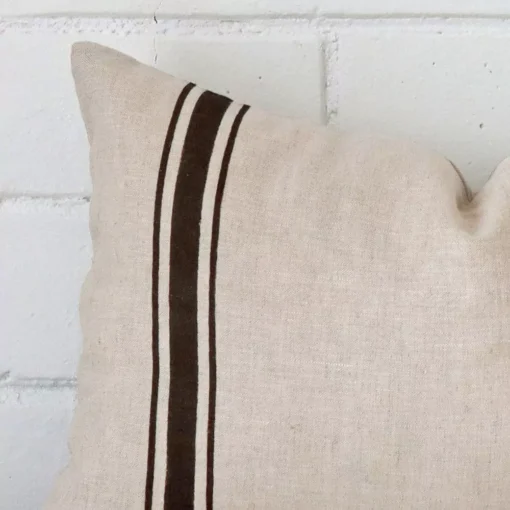 A macro image of the top left corner of this striped linen cushion. It is possible to see the finer detail of the rectangle shape and charcoal colour.