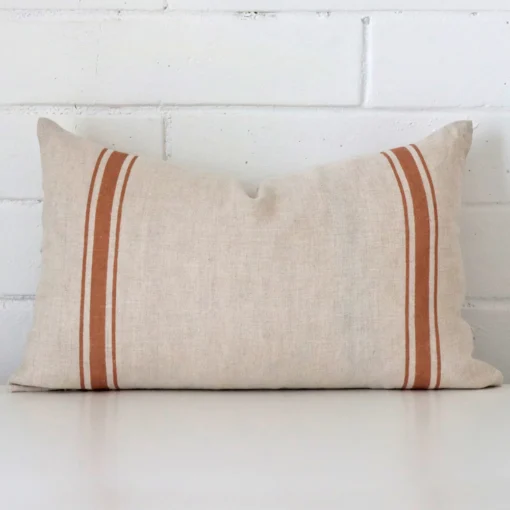 Gorgeous rectangle linen cushion cover that has a terracotta hue. It has a graceful striped design.