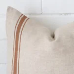Zoomed in visual of linen square cushion cover in terracotta. The intricacies of its striped design are visible.