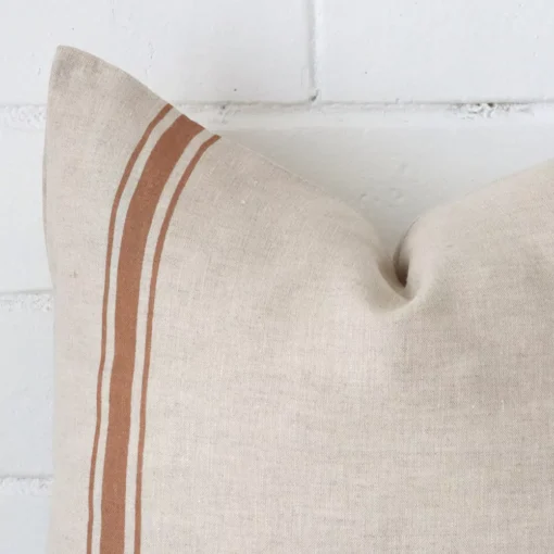 Zoomed in visual of linen square cushion cover in terracotta. The intricacies of its striped design are visible.