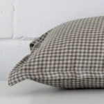 Lateral viewpoint of this designer square cushion. The gingham design is shown from the side showing the front and rear panels.
