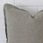 A detailed shot of this gingham cushion cover that has designer fabric and has a square size.