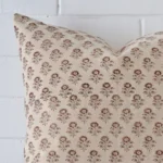 The corner of this designer square cushion cover is shown close up. The floral design is shown in greater detail
