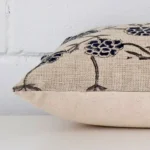 Side perspective showing seam of rectangle cushion cover that has a floral motif on its designer fabric.