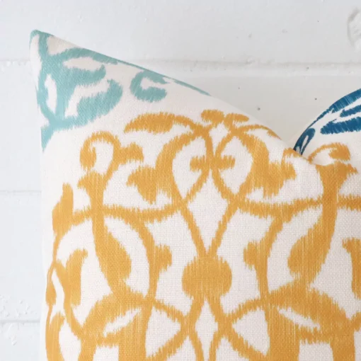 The corner of this linen square cushion cover is shown close up. The patterned design is shown in greater detail.