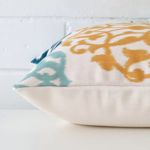 Close side shot of this linen cushion cover. The viewpoint shows how the square design and patterned decorative finish meet along its edge.