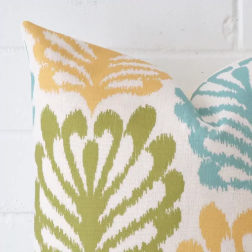 Cropped shot of top left corner of this patterned cushion cover. This viewpoint shows the linen fabric and square shape with more precision.