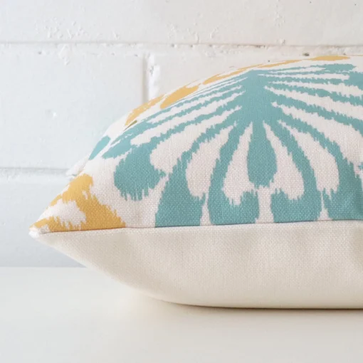 Side perspective showing seam of square cushion cover that has a patterned motif on its linen fabric.