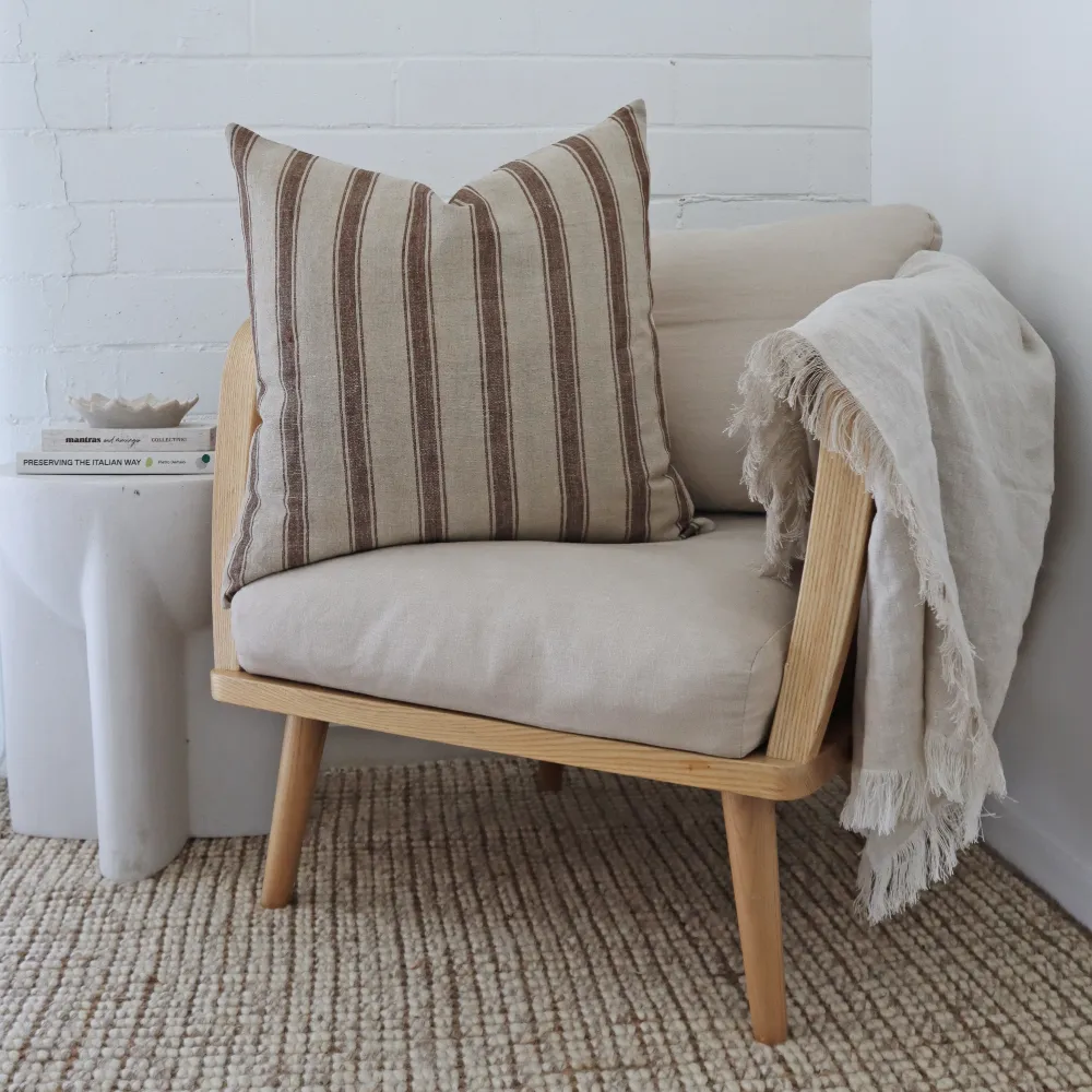 A large cushion styled to the side of an armchair.