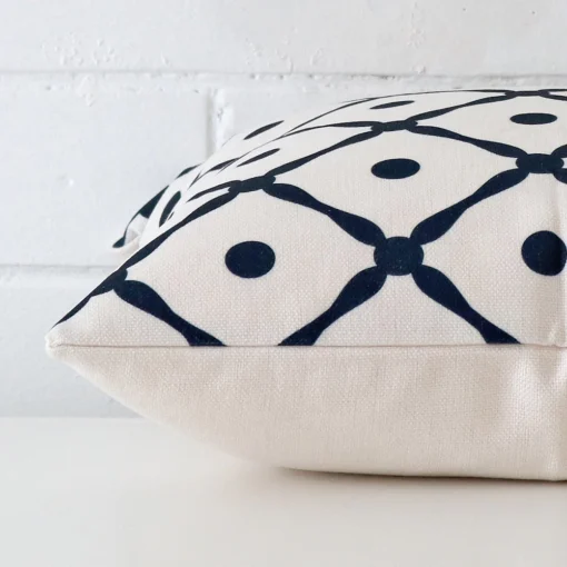 Lateral viewpoint of this linen square cushion. It has a geometric design on its front panel.