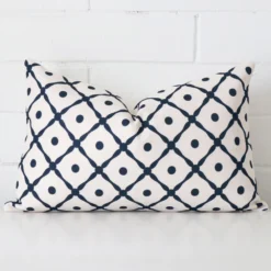 Cushion cover sits against a white wall. It is constructed from a superior looking linen material and has rectangle dimensions.