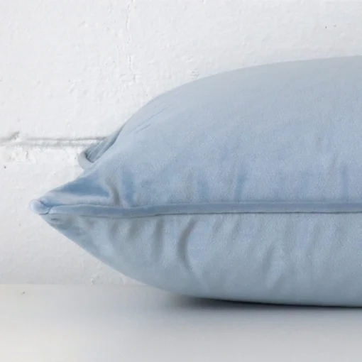 Ligt blue cushion cover laid on its back side. The image shows a side-on view of the velvet material and its rectangle dimensions.