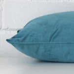 Rectangle light teal cushion laid flat. This view shows the style and velvet fabric from side on.