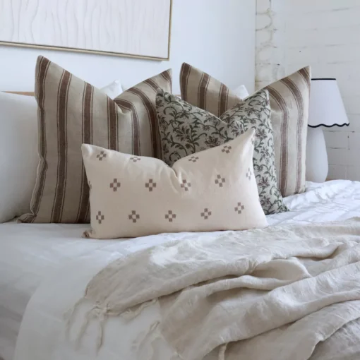 A bright bedroom showcasing 4 elegant designer cushions.
