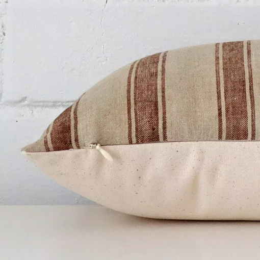Striped cushion cover laid on its back side. The image shows a side-on view of the designer material and its square dimensions.