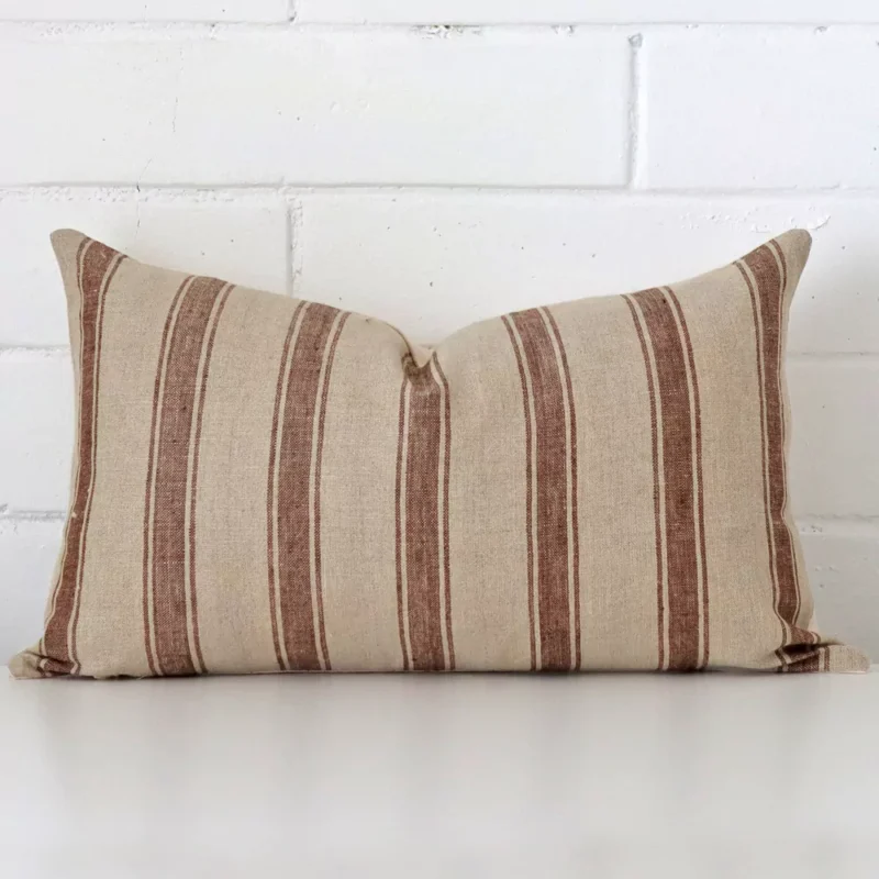luka-striped-designer-cushion-cover-rectangle-art110-30 Bold rectangle cushion positioned in front of white brickwork. Its striped style pops on the designer fabric.