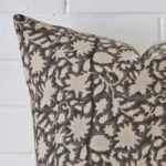 Very close photo of floral cushion. The shot shows the designer material and square dimensions with more clarity.