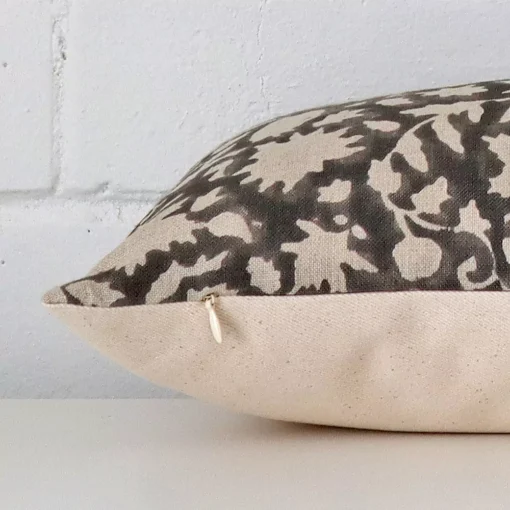 Designer cushion laying on its side. The floral design and its rectangle size are visible.