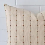 A macro image of the top left corner of this striped designer cushion. It is possible to see the finer detail of its square shape.