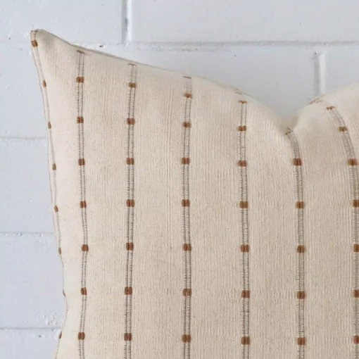 A macro image of the top left corner of this striped designer cushion. It is possible to see the finer detail of its square shape.