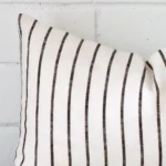 Close range image of striped cushion. The rectangle size and linen material can be seen in detail.