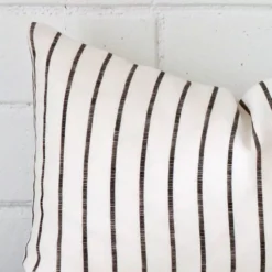 Close range image of striped cushion. The rectangle size and linen material can be seen in detail.