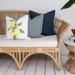 A set of 3 Mediterranean outdoor couch cushions sits neatly in a corner of a rattan seat.