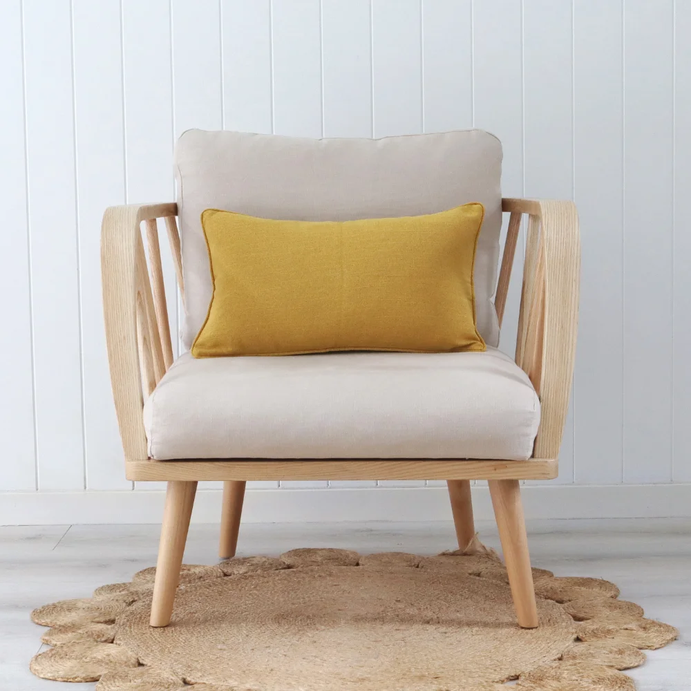 A mustard cushion centered on an elegant chair.