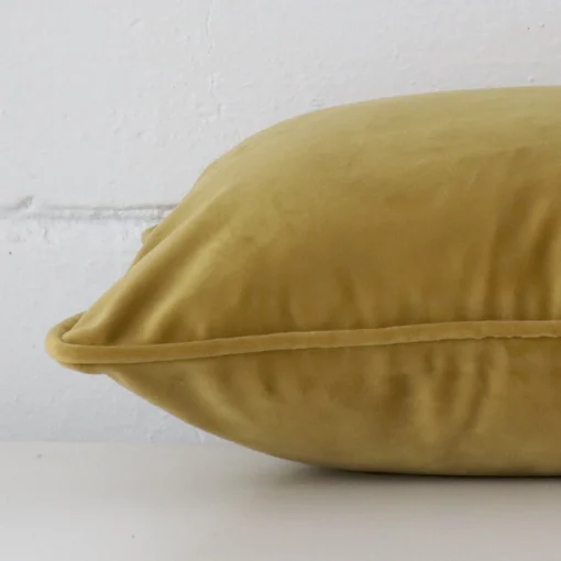 Side edge of rectangle cushion. The velvet material and mustard colour can be seen from this lateral viewpoint.